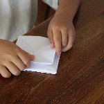 折り紙を折る子供の手