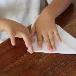 折り紙を折る子供の手